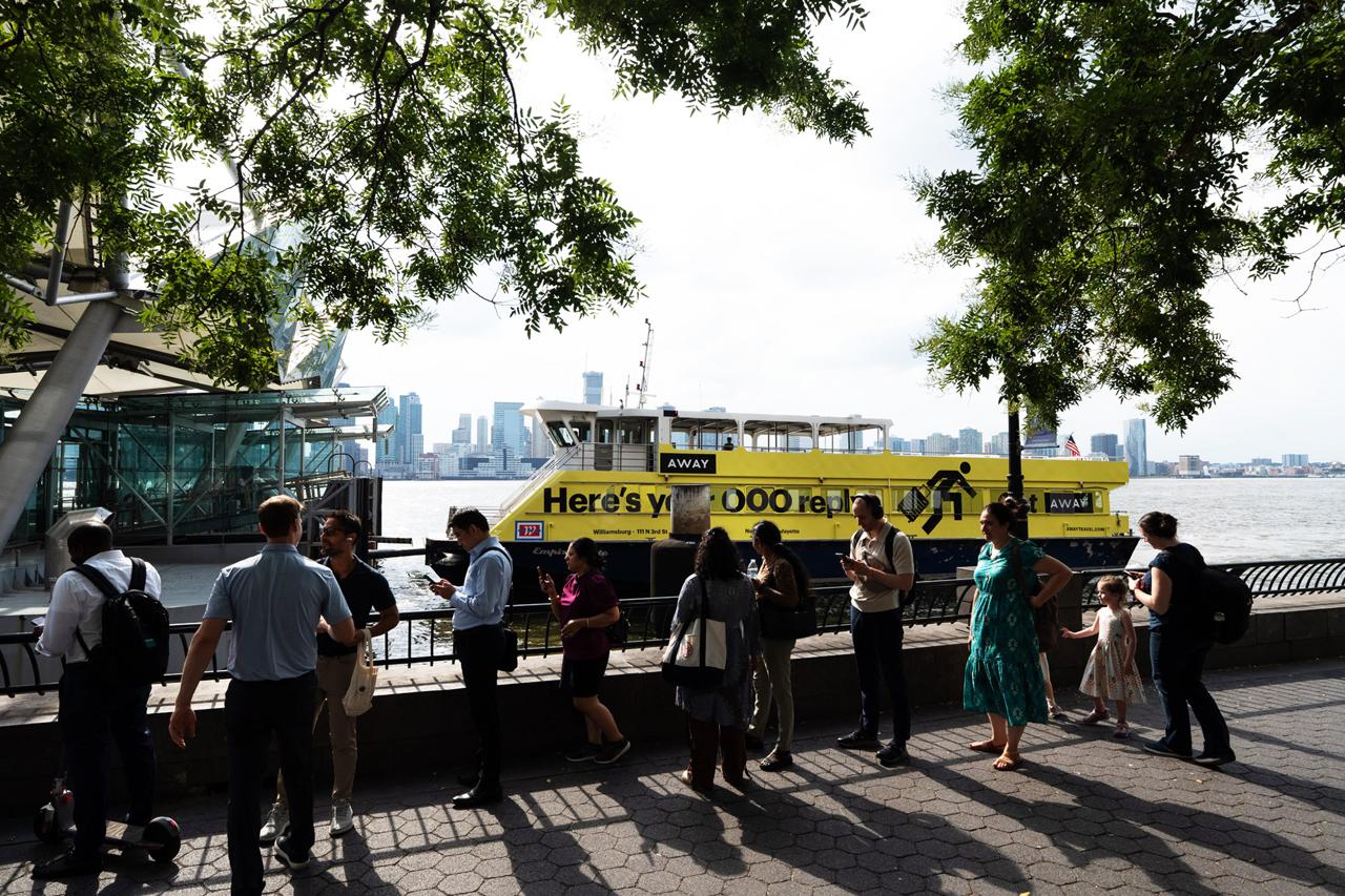 Away luggage branded yellow ferry docked in NYC