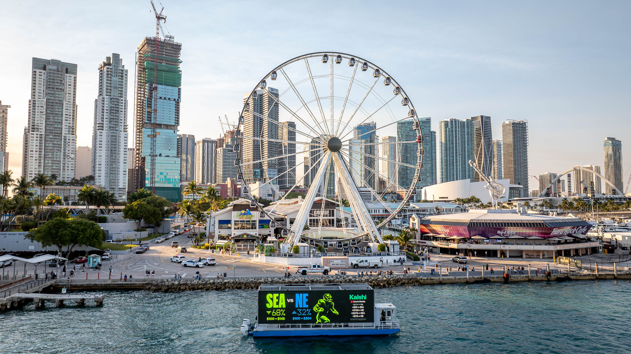 Kalshi digital billboard boat in Biscayne Bay with Miami skyline and ferris wheel